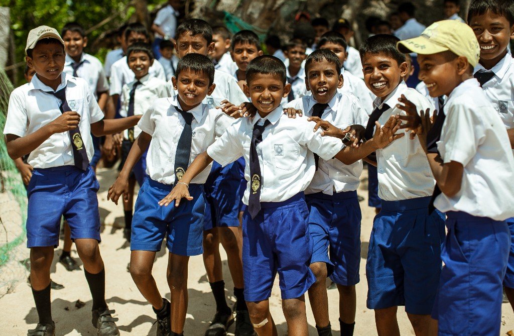 School children in uniform smiling and playing in a school yard