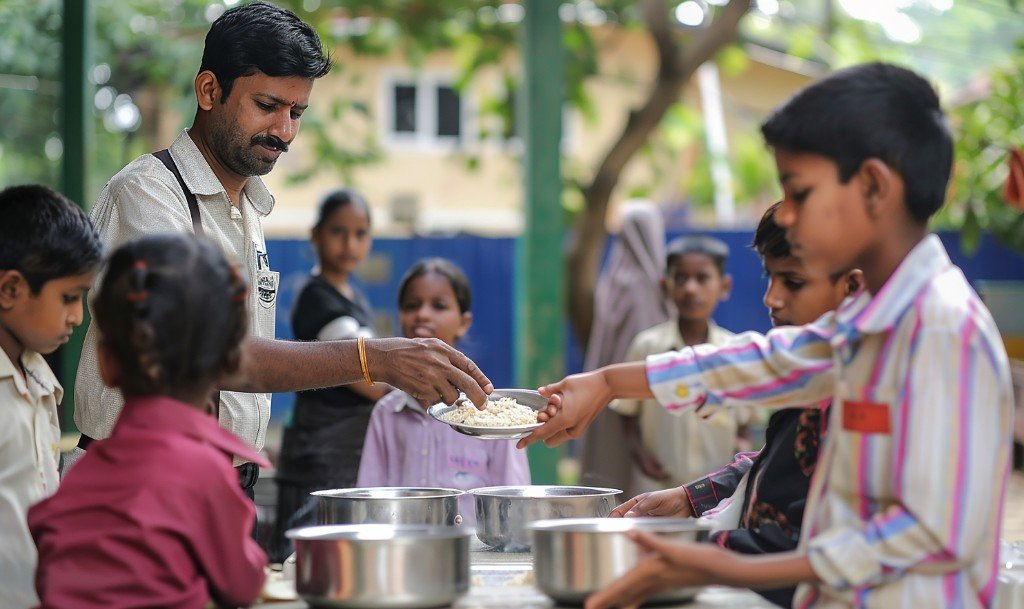 Volunteers serving food to children during a community programme
